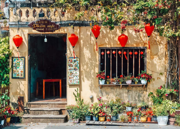 Colorful café front adorned with plants and red lanterns in Hoi An, Vietnam