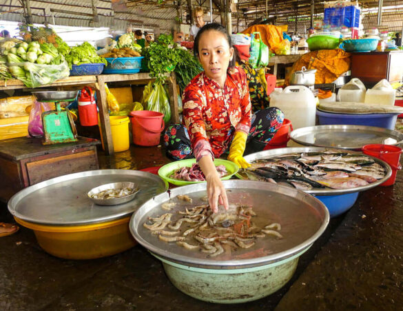 A vendor at a wet market in Vietnam displaying fresh seafood