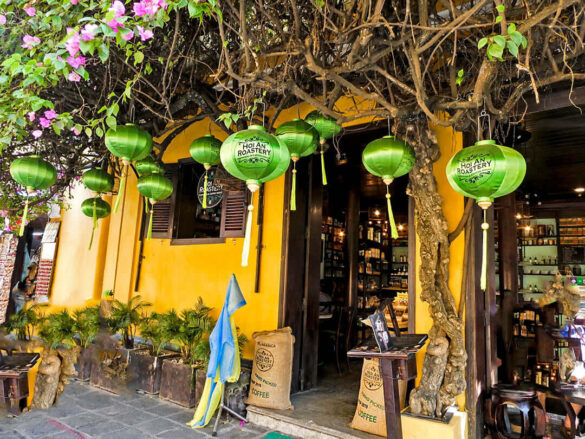 The exterior of Hoi An Roastery Cafe with hanging green lanterns in Vietnam