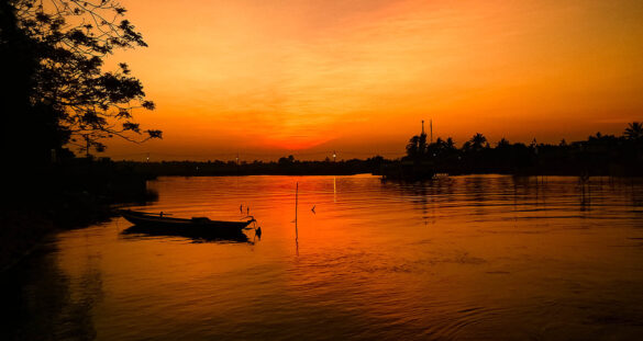 Silhouette of a boat against the sunset in Hoi An, Vietnam