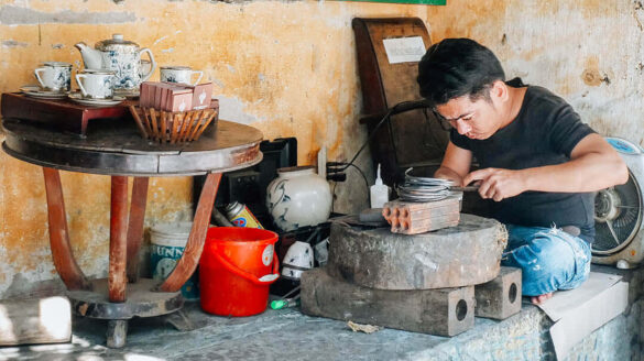 A skilled artisan focusing on his craft on a Hoi An street