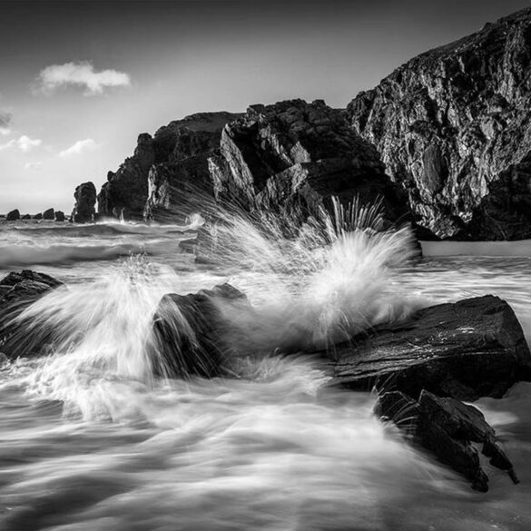 Powerful ocean waves crashing against rocks on Dalmore beach.